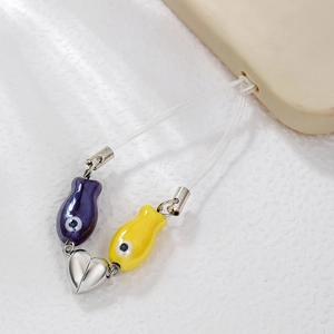 Ocean style ceramic fish phone charm with heart metal buckle on white textured background