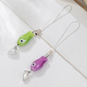 Macro view of green and purple ceramic fish charms with magnetic heart connection