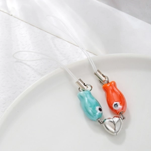 Detail of magnetic ceramic fish charms with blue and orange glaze for couple mobile chains