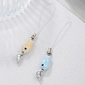 Detail of blue and yellow ceramic fish charms with magnetic heart clasps and lanyards