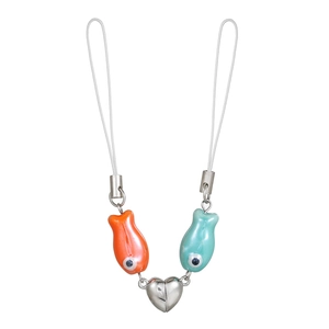 Macro shot of orange and blue ceramic fish pendants connected by a silver magnetic heart charm