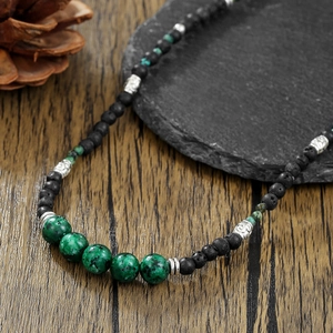 Bohemian lava stone and green jasper beaded long necklace for men on stone surface