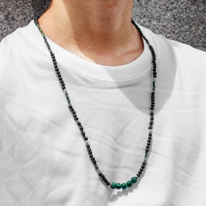 Detail of men's long beaded necklace with black lava stones and green malachite accents