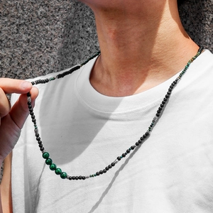 Detail of bohemian men's beaded necklace with black lava stone and green malachite beads