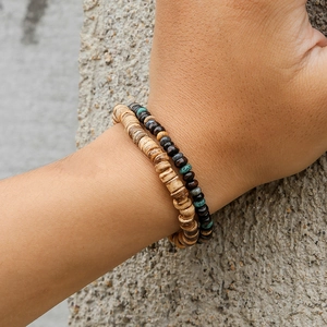 Detailaufnahme von elastischen Armbändern aus Naturholzperlen im Boho-Stil am Handgelenk