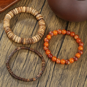 Set bracciale retrò da uomo con perle di legno e agata rossa su sfondo di legno