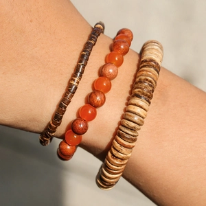 Dettaglio di bracciali multistrato fatti a mano con perle in legno e pietre di agata