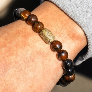 Tiger eye and obsidian beaded bracelet with green stone centerpiece on male wrist