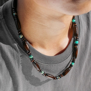 Bohemian vintage long necklace with wood beads and turquoise stones on casual grey shirt