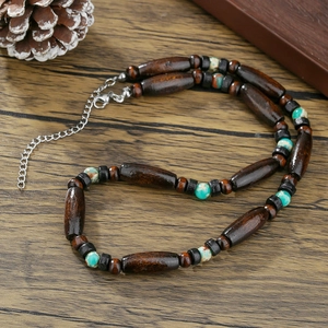 Bohemian vintage long necklace with wood beads and turquoise stones on rustic background