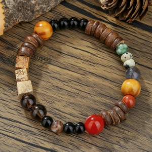 Bracelet fait main en perles de bois, agate et pierres naturelles sur fond de bois sombre