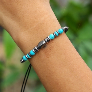 Detail of turquoise beads and black hematite spacer bracelet worn on a man's wrist