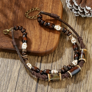 Detail of beach style multilayer leather bracelet with wood beads and skull charm