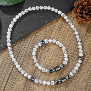 Conjunto de joyas de turquesa blanca y hematita con amuleto de ojo en mesa madera