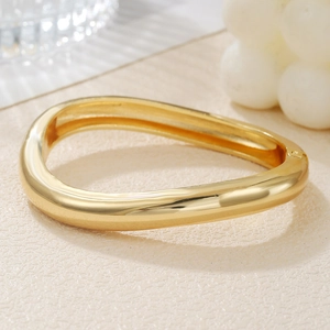 Modern chunky gold wave cuff bracelet with a polished mirror finish for a bold look