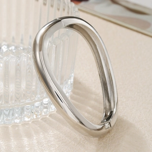 Detailed close-up of a silver geometric wave hinge bracelet with high-polish finish