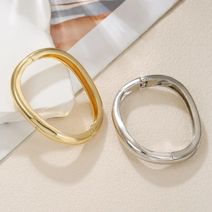 Modern geometric spring cuff bracelet set in polished gold and silver metal finishes