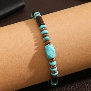 Detalle de una pulsera bohemia de turquesa y cuentas de madera con piezas de bronce