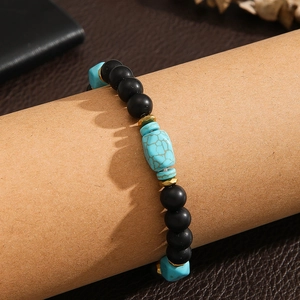 Pulsera vintage para hombre con cuentas negras mate y turquesa en un soporte de exhibición