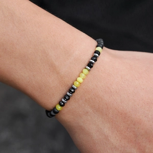 Pulsera minimalista para hombre con cuentas negras mate y detalles en amarillo
