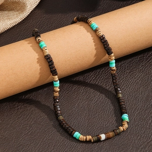 Collier bohème en perles de coco et bois avec accents menthe sur fond en cuir marron