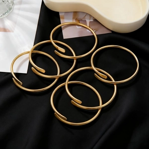 Set di 6 bracciali rigidi aperti minimalisti dorati su un elegante sfondo in raso nero