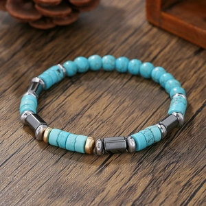 Detail van herenarmband met turquoise kralen en hematiet op donker houtoppervlak