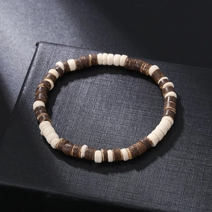 Detalle de pulsera de cuentas de madera y coco sobre un joyero negro con textura