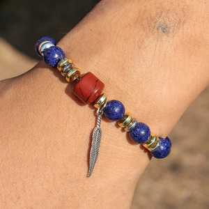 Detailed shot of ethnic bead bracelet with blue stones and silver feather charm