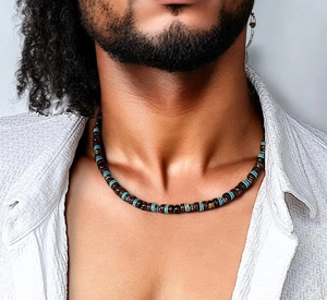 Détail d'un collier pour homme avec perles en bois et touches turquoise sur chemise blanche