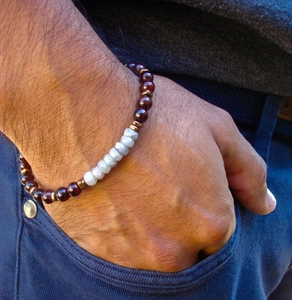 Close-up of men's natural stone bead bracelet with dark red garnet and bronze accents