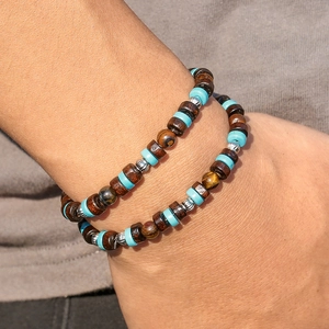 Gros plan d'un collier pour hommes avec turquoise, oeil de tigre et perles en bois