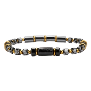 Detailed macro view of black cylindrical beads and gold spacers on a men's stone bracelet