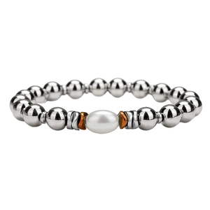 Macro detail of beaded bracelet featuring silver metal beads and a central white pearl