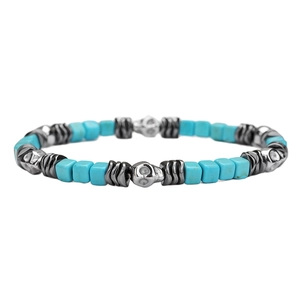 Detailed macro view of square turquoise beads and metal skull charms on the bracelet