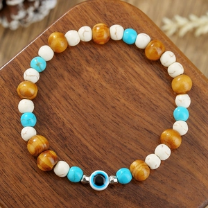 Detailed close-up of handmade evil eye beaded bracelet with wood and turquoise stones