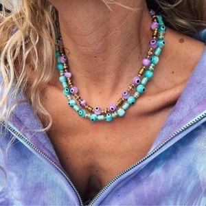 Gros plan d'un collier de perles bohème à plusieurs rangs avec perles mauvais œil