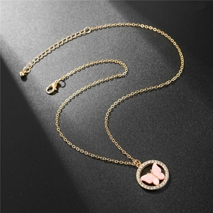 Détail du collier doré avec pendentif papillon rose orné de strass brillants et fermeture