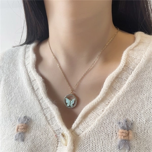 Détail d'un collier papillon doré avec diamants en cristal sur la clavicule d'un mannequin