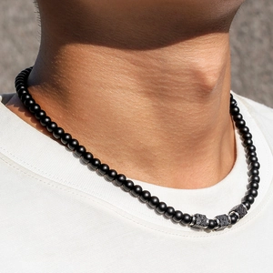 Detail of men's matte black beads and porous volcanic stone necklace with silver spacers