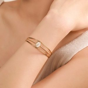 Minimalist gold stainless steel open bangle featuring a multilayer design with cat-eye gemstone