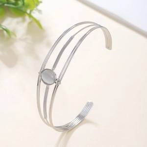 Detail of silver multi-layer open cuff bracelet with oval gemstone and wire wrapping