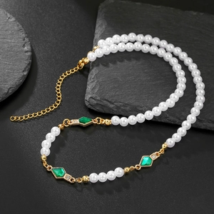 Elegant men's faux pearl necklace with green diamond pendant on black stone background