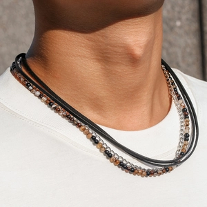 Detail of layered men's necklace with black leather, metal chain and tiger eye beads