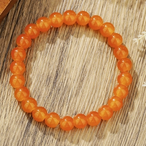Bracelet en perles d'agate orange naturelle sur bois rustique avec fleurs séchées