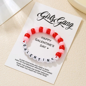 Handgefertigtes Armband mit rosa und roten Galentine-Perlen und Goldherz auf Displaykarte