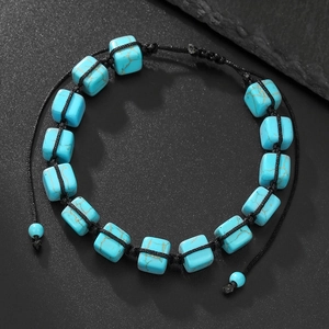 Detalle de cuentas cuadradas de turquesa y cordón negro trenzado en pulsera de yoga