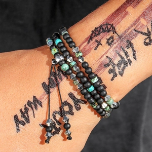 Detail of multi-layer beaded bracelet with matte black beads and turquoise accents