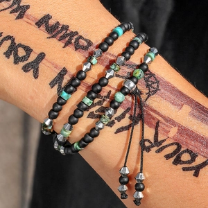 Detail of adjustable triple-layer beaded bracelet featuring matte black and turquoise stones