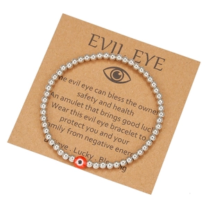 Detail of silver beaded Evil Eye friendship bracelet on a kraft gift card display